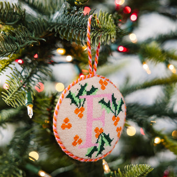Decorative Christmas ornament with letter 'F' on a Christmas tree.