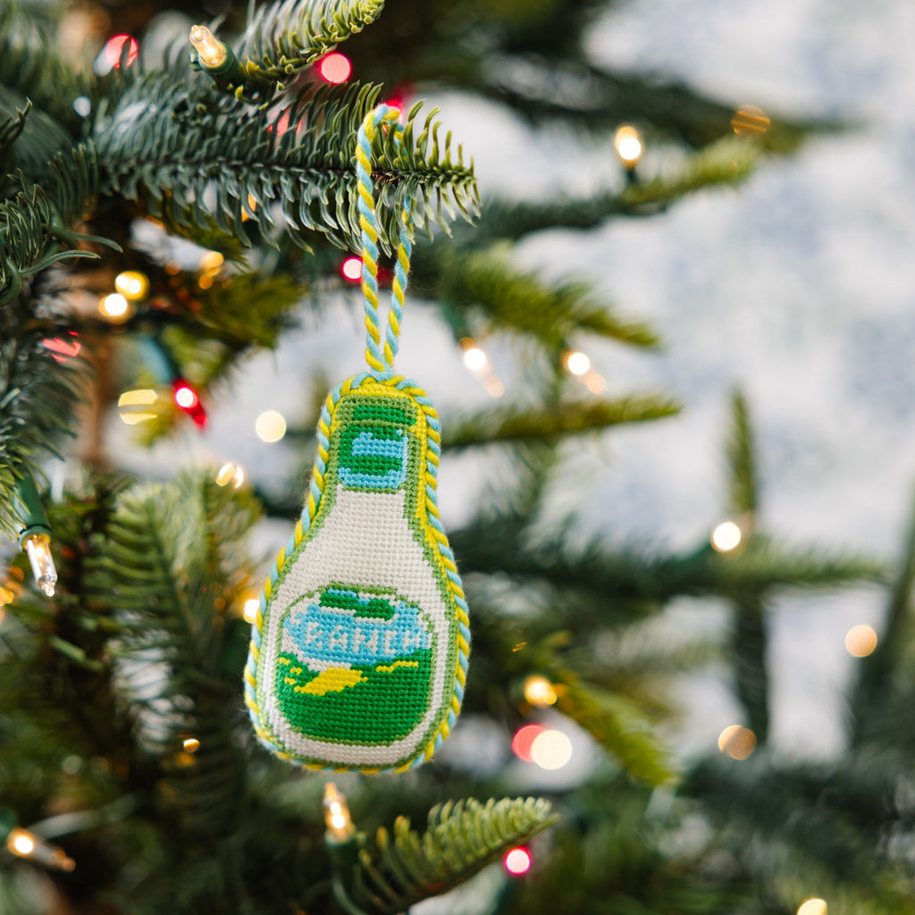Decorative bottle ornament on a Christmas tree with lights in the background