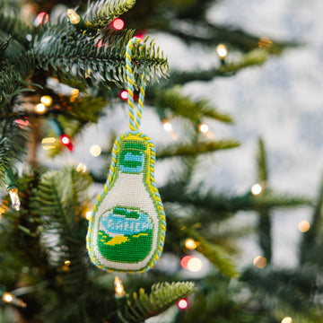 Decorative bottle ornament on a Christmas tree with lights in the background