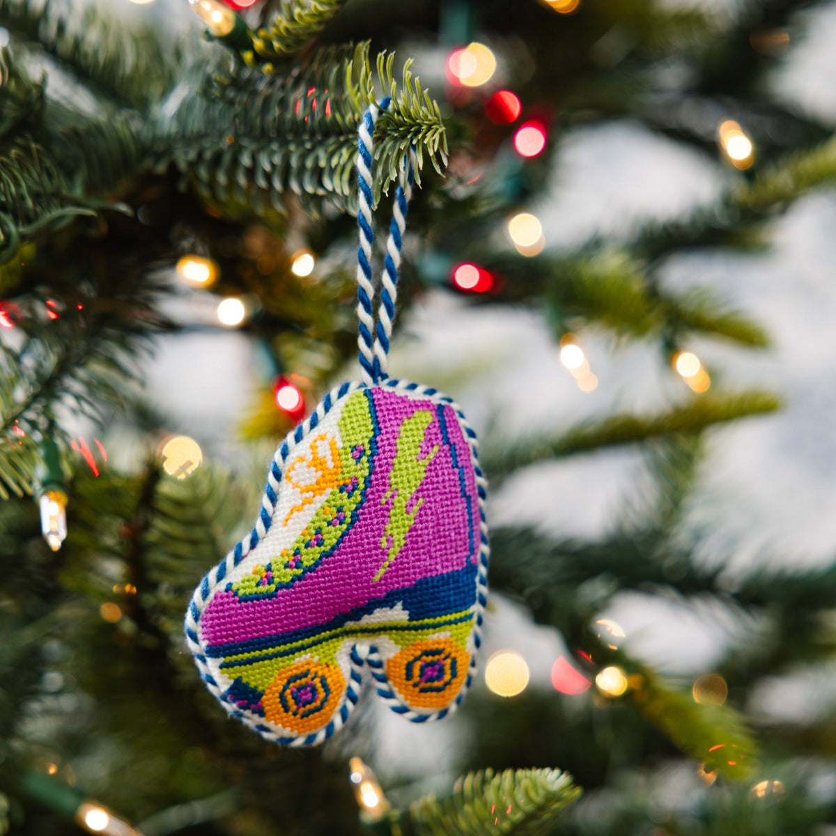 Colorful ornament on a Christmas tree with blurred lights in the background