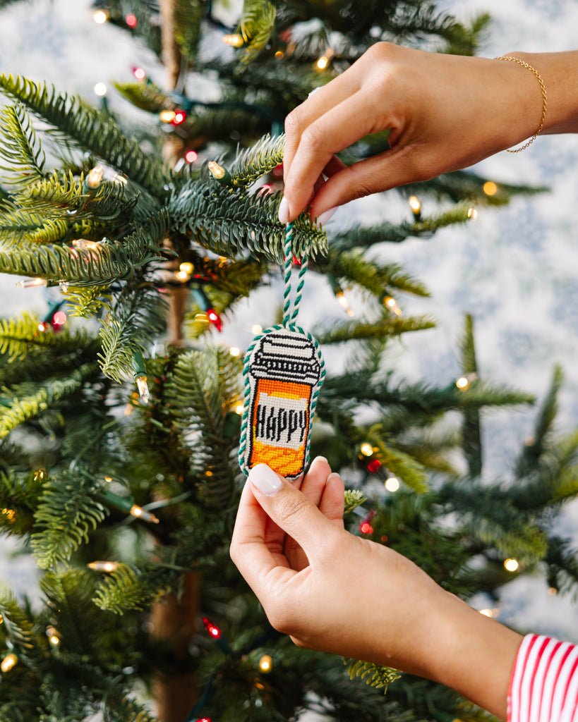 Person hanging a small ornament on a decorated Christmas tree