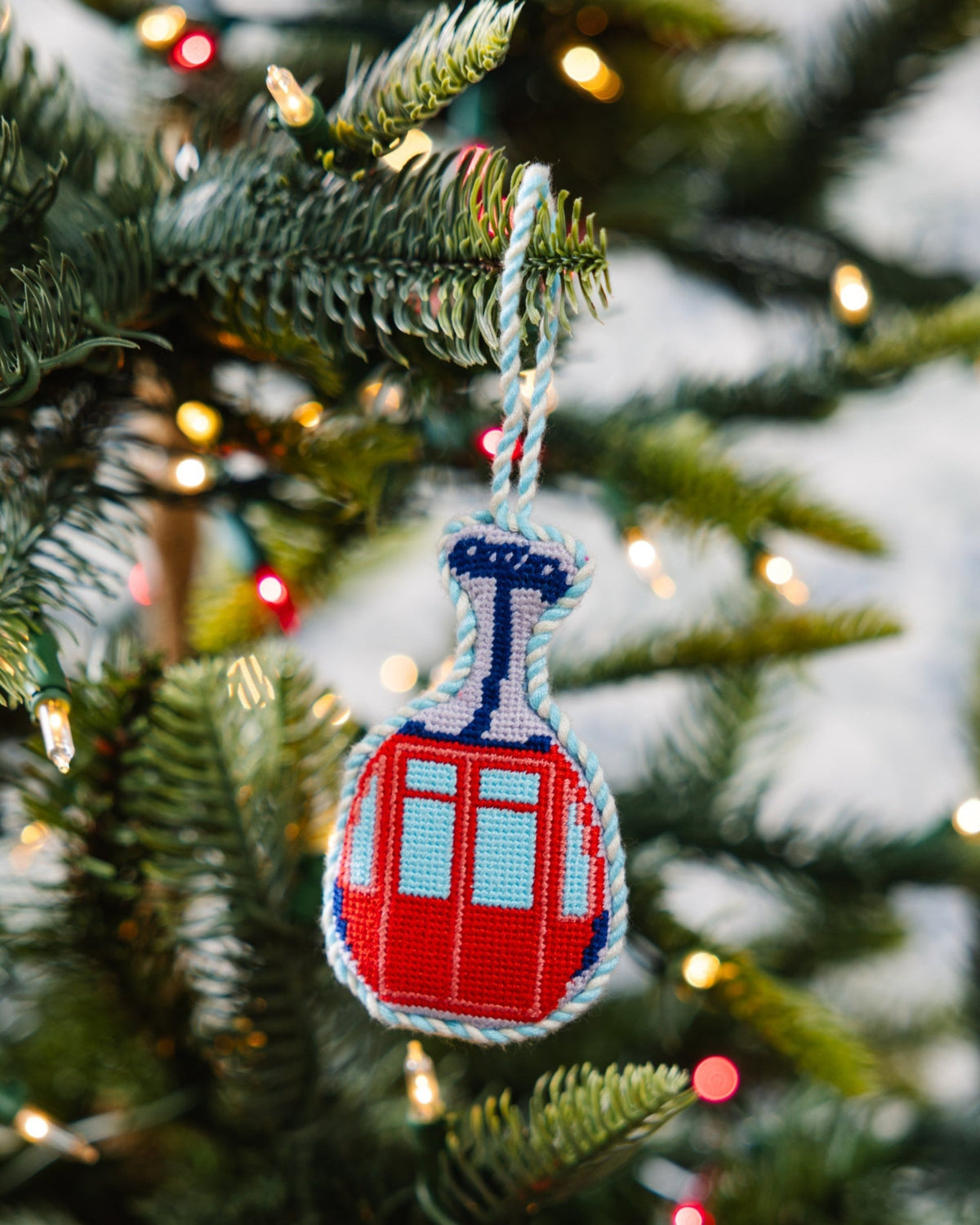 Decorative gondola ornament on a Christmas tree with blurred lights in the background