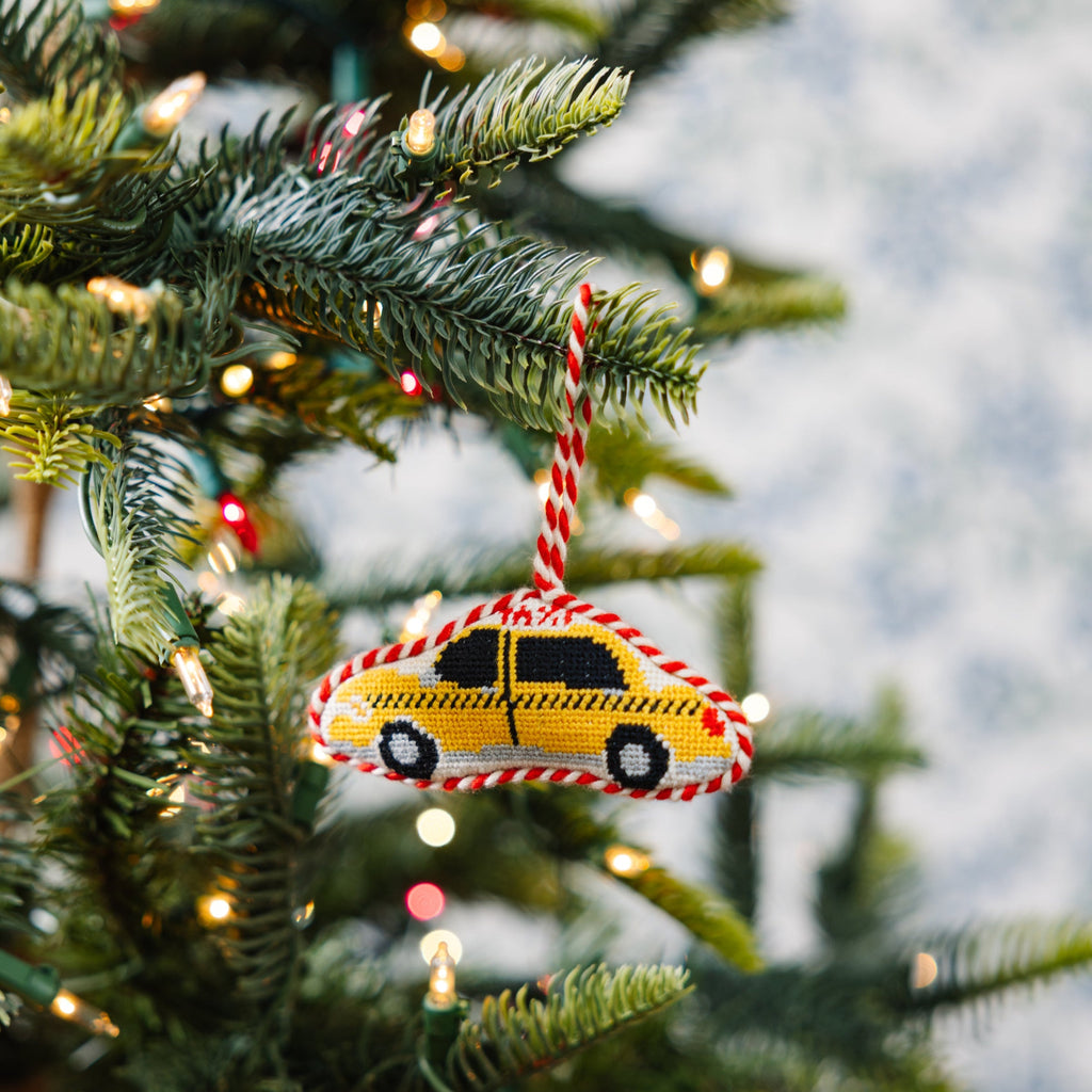 Decorative Christmas ornament shaped like a taxi on a Christmas tree with lights.