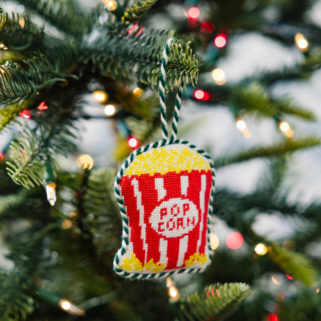 Decorative popcorn container ornament on a Christmas tree with lights.