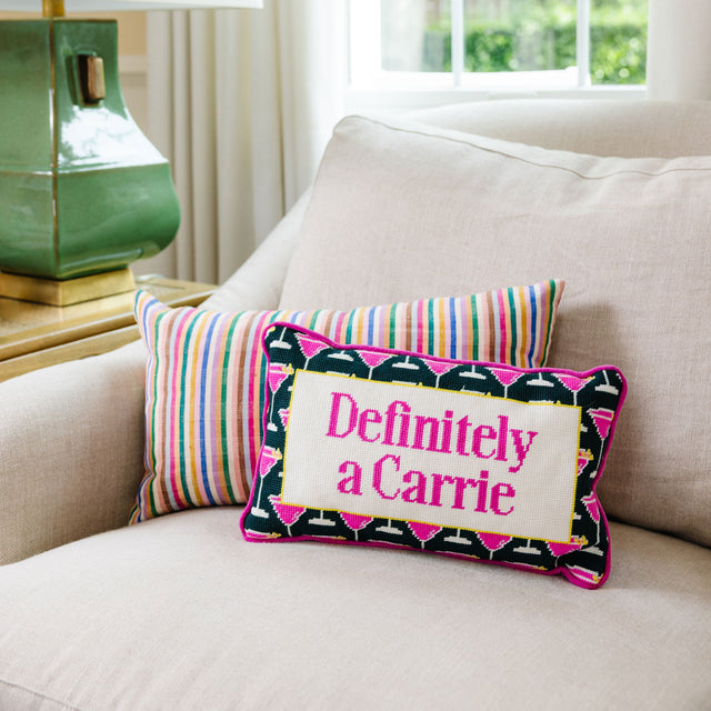 Decorative pillow with 'Definitely a Carrie' text on a couch next to a lamp.