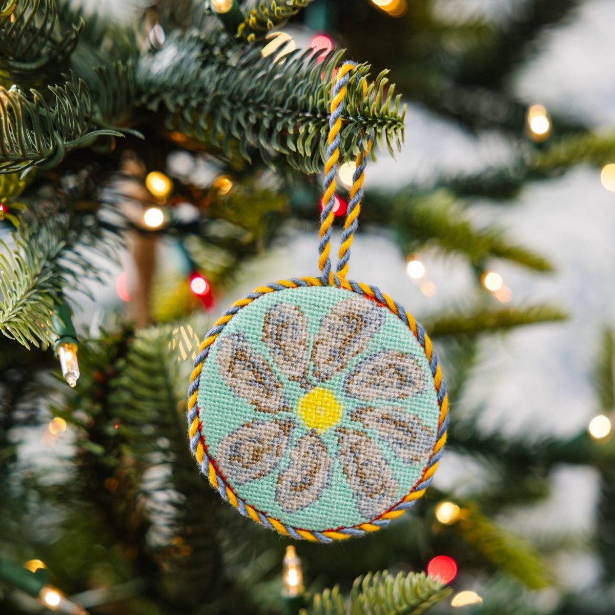 Decorative ornament with floral design hanging on a Christmas tree