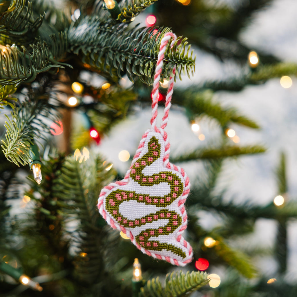 Decorative Christmas ornament on a tree with blurred lights in the background