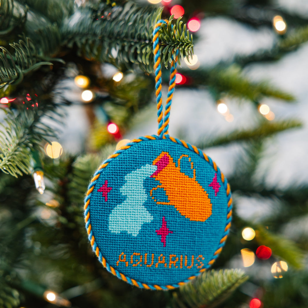 Decorative Aquarius ornament on a Christmas tree with blurred lights in the background