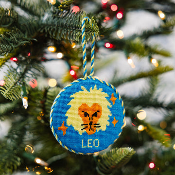 Decorative ornament with a lion design and 'Leo' text on a Christmas tree.
