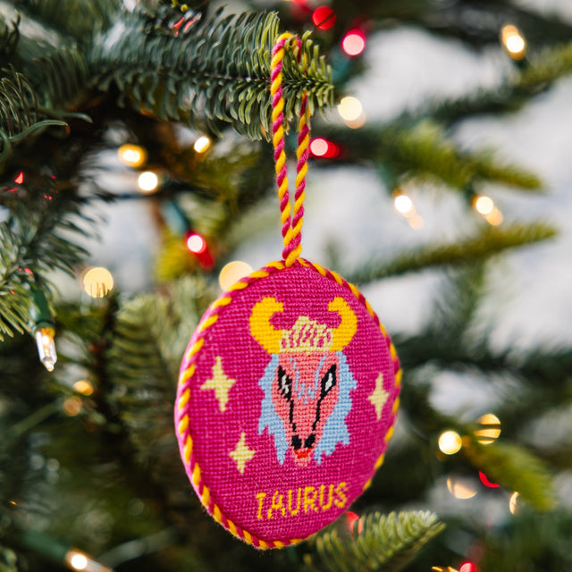 Decorative Christmas ornament with a zodiac design hanging on a tree.
