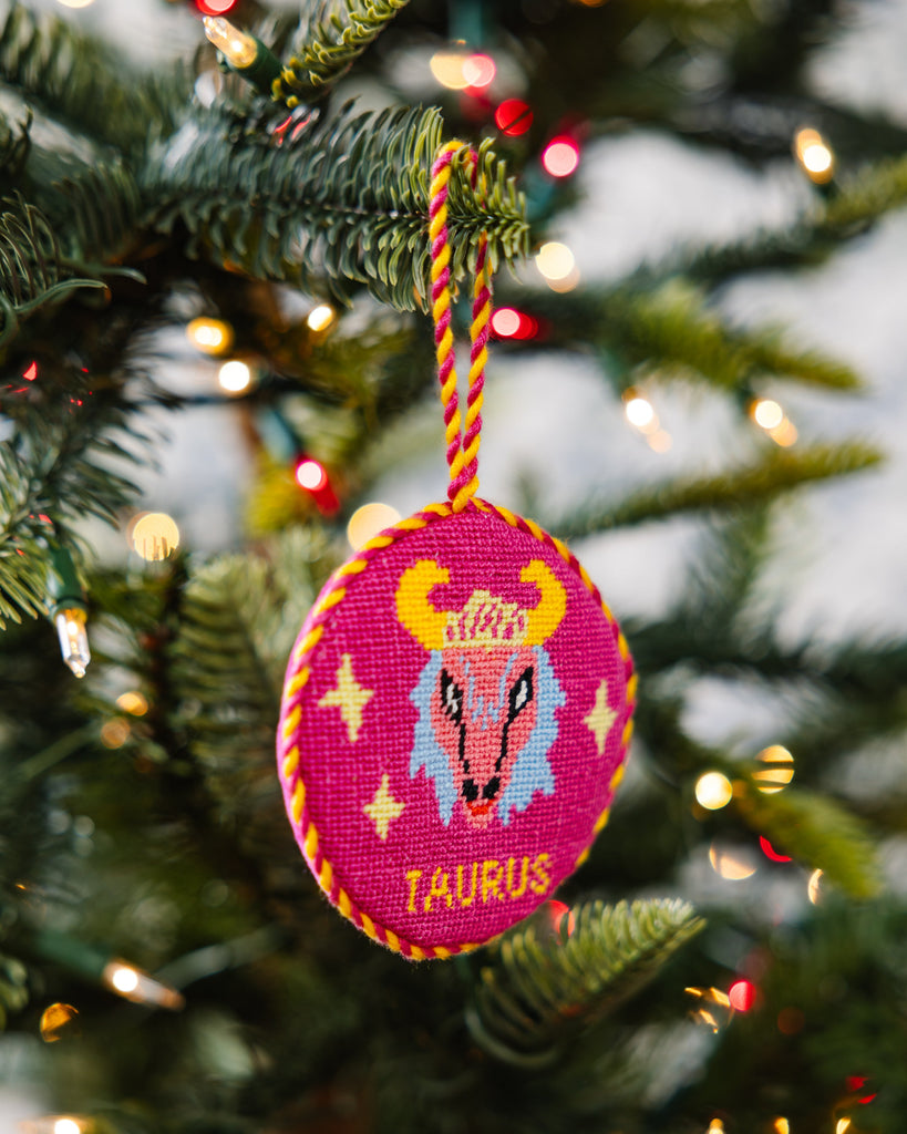 Decorative Christmas ornament with a zodiac design hanging on a tree.