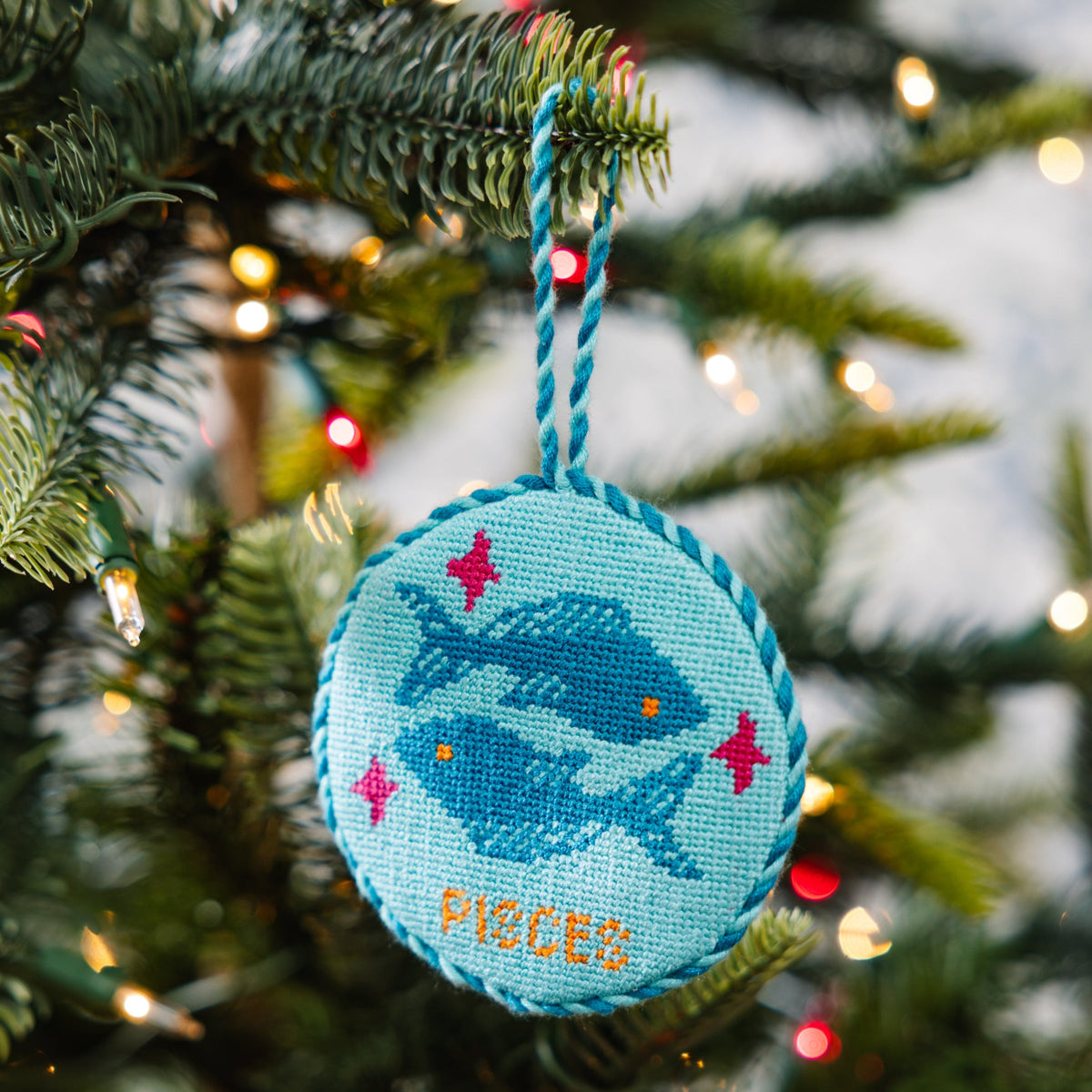 Decorative ornament with fish design hanging on a Christmas tree.
