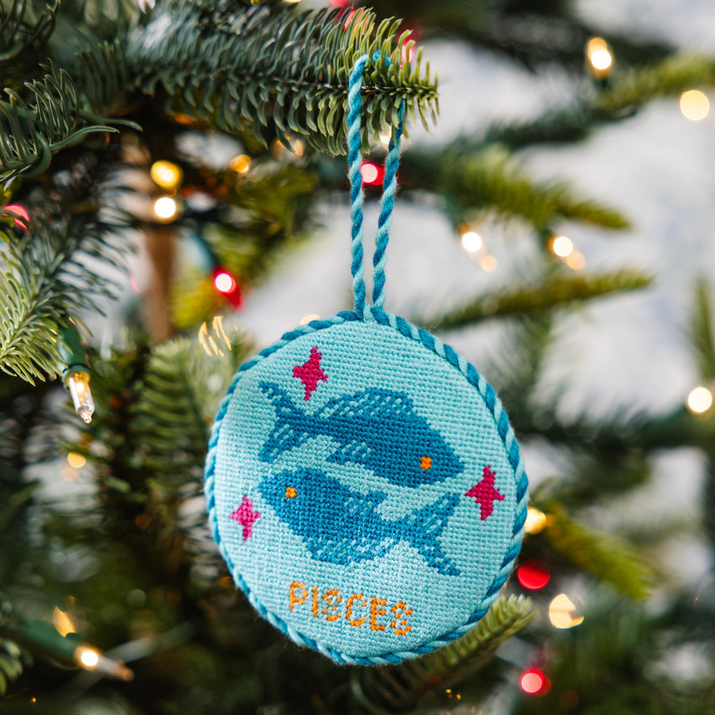 Decorative ornament with fish design hanging on a Christmas tree.