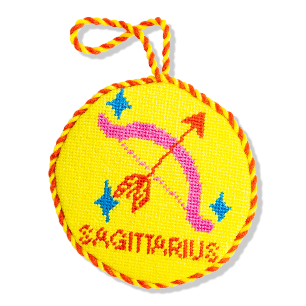 Yellow circular object with zodiac sign design and 'Sagittarius' text on a white background