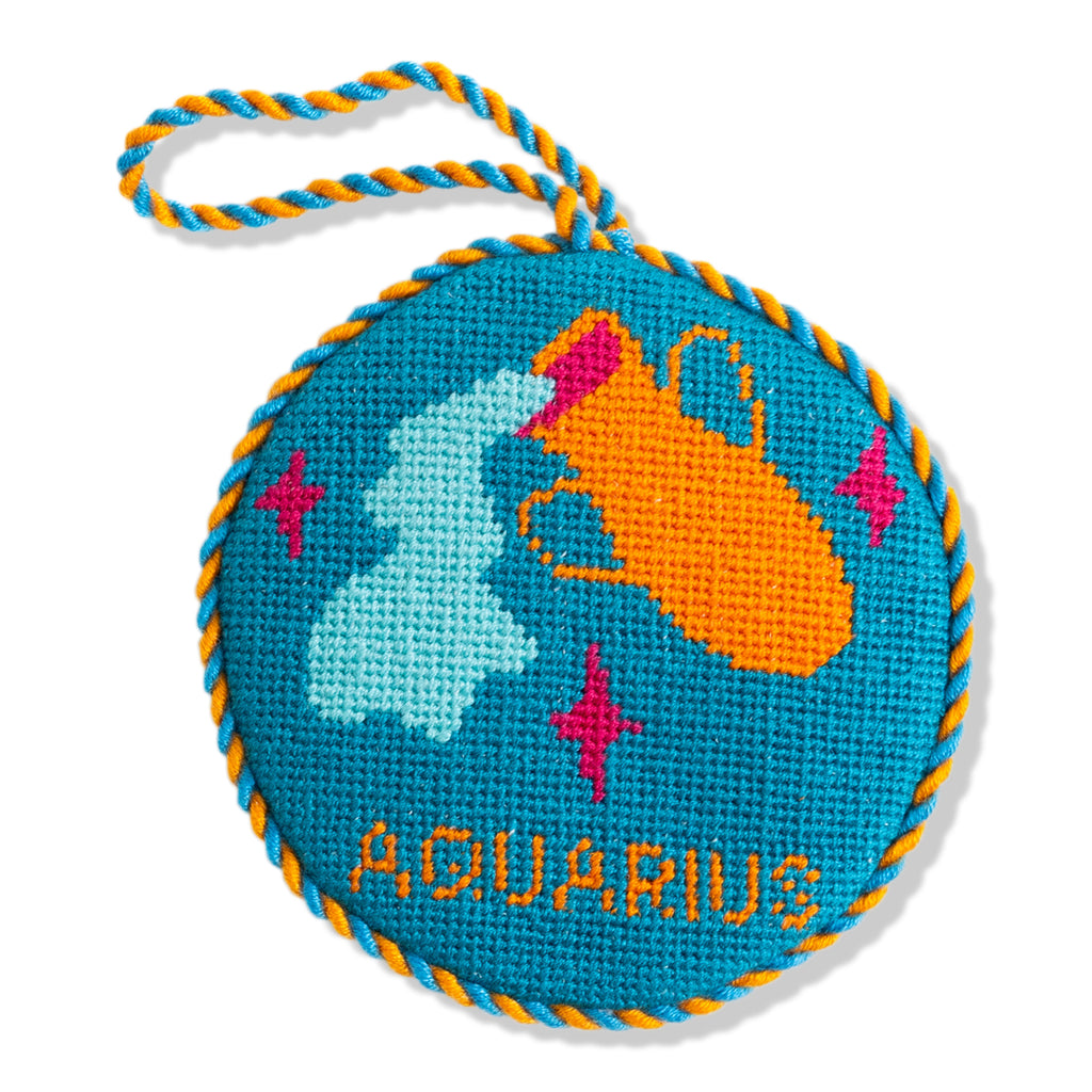 Round blue embroidered item with Aquarius design on a white background