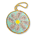 Round needlepoint ornament with floral design and colorful rope on a white background