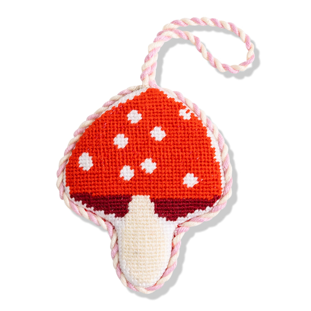 Mushroom-shaped toy with a red cap and white spots on a white background