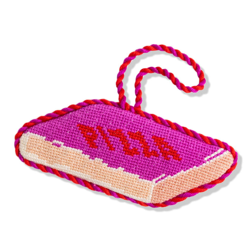 Pink and red knitted dog toy with a rope handle on a white background