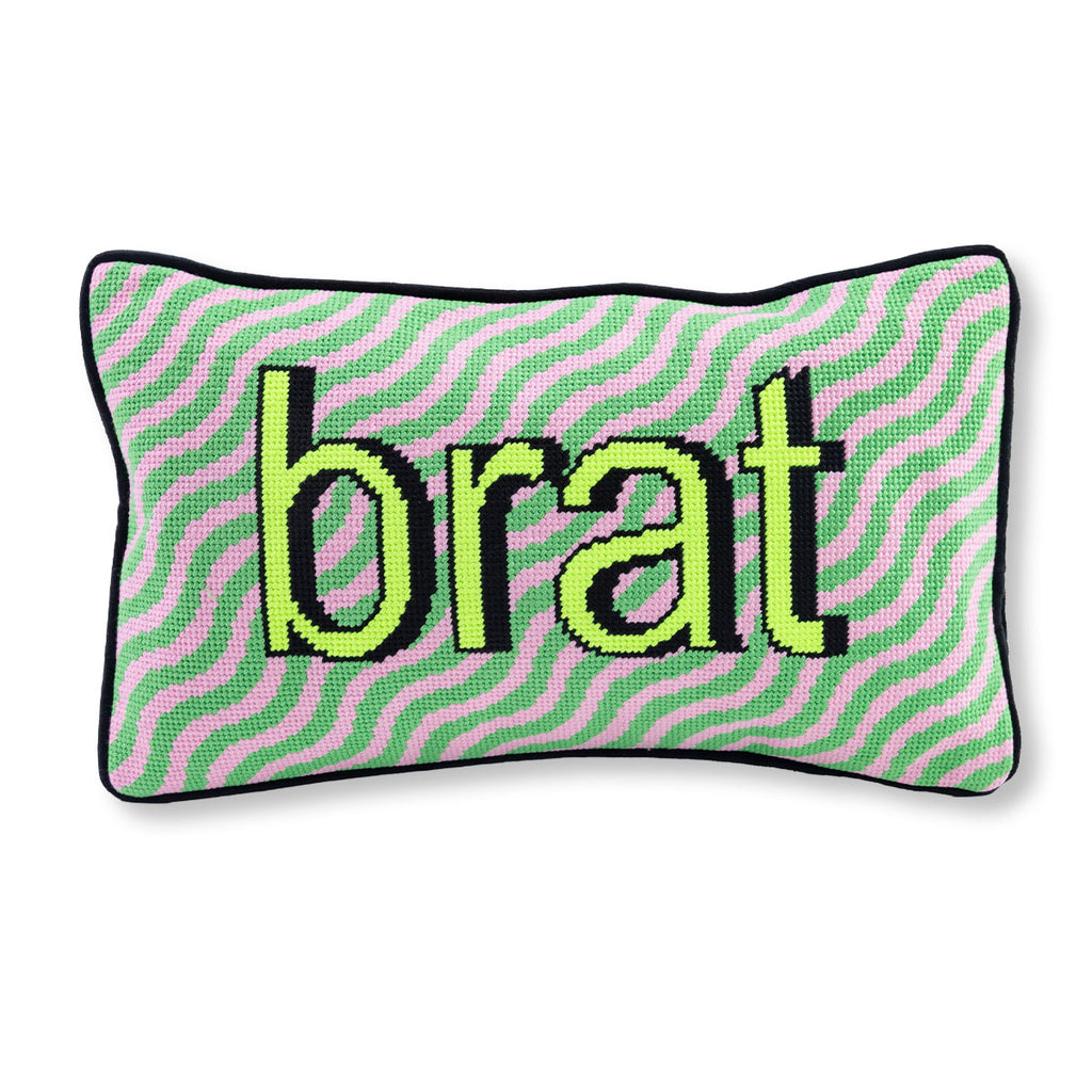 Pillow with 'brat' text on a pink and green striped background