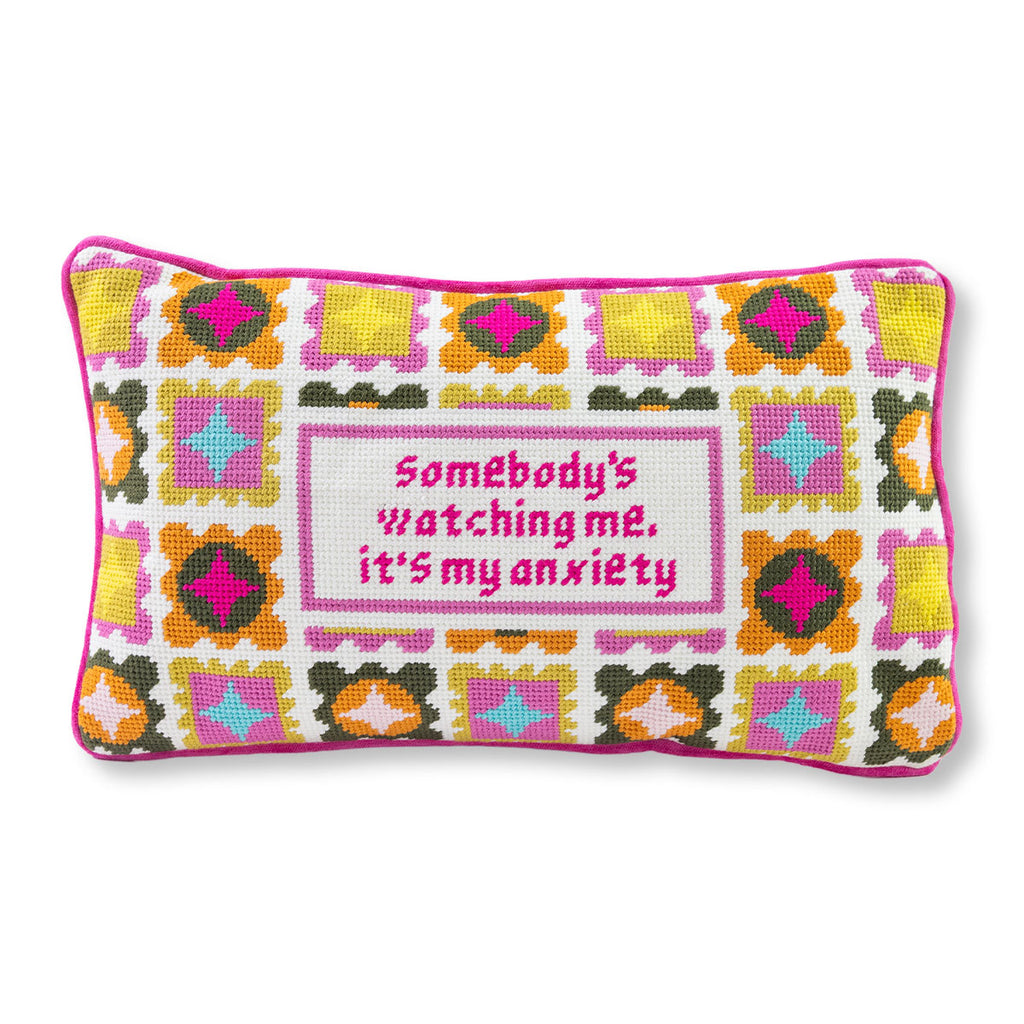 Decorative pillow with colorful pattern and text on a white background