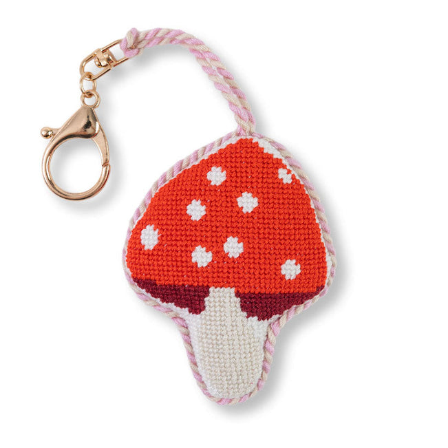 Mushroom-shaped keychain with red cap and white spots on a white background