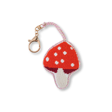 Mushroom-shaped keychain with red cap and white spots on a white background