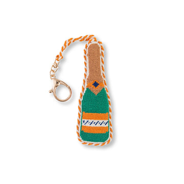 Crocheted champagne bottle keychain with orange and green design on a white background