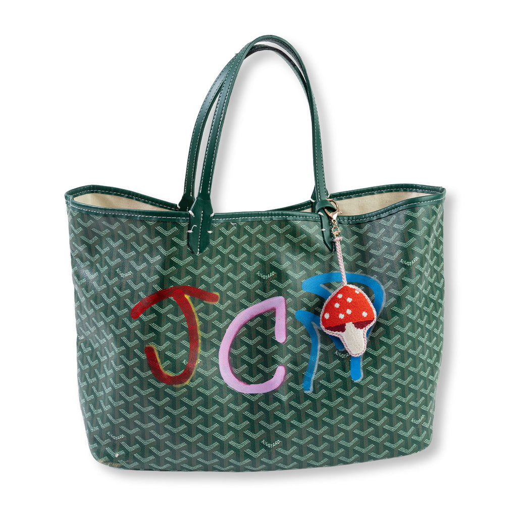 Green patterned tote bag with colorful initials and a mushroom charm on a white background