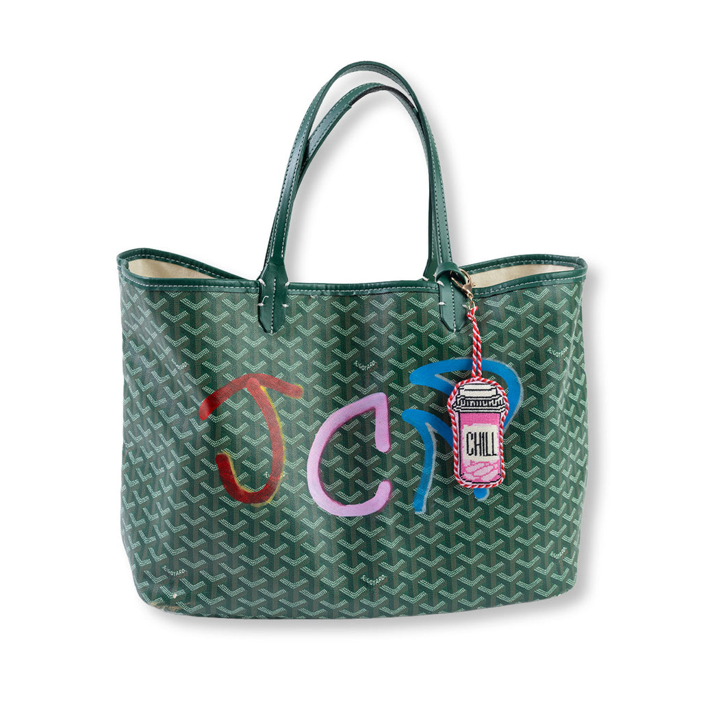 Green handbag with colorful letters and a 'Chill' charm on a white background