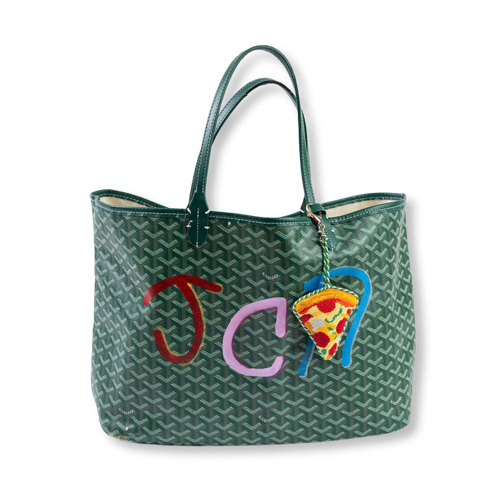 Green patterned handbag with colorful embroidered letters and a pizza slice charm on a white background