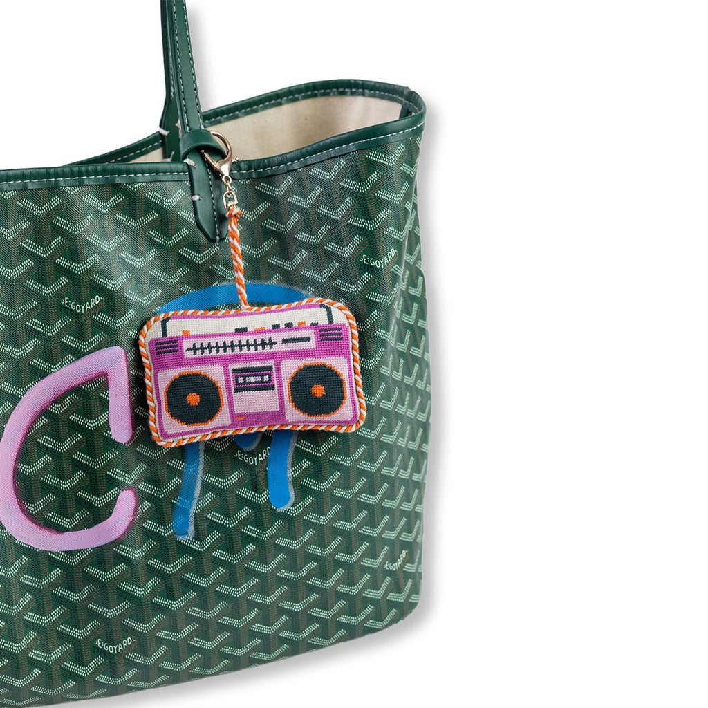 Green patterned handbag with a colorful radio charm on a white background