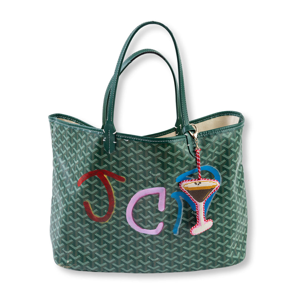Green patterned handbag with colorful 'JCL' and martini glass charm on a white background