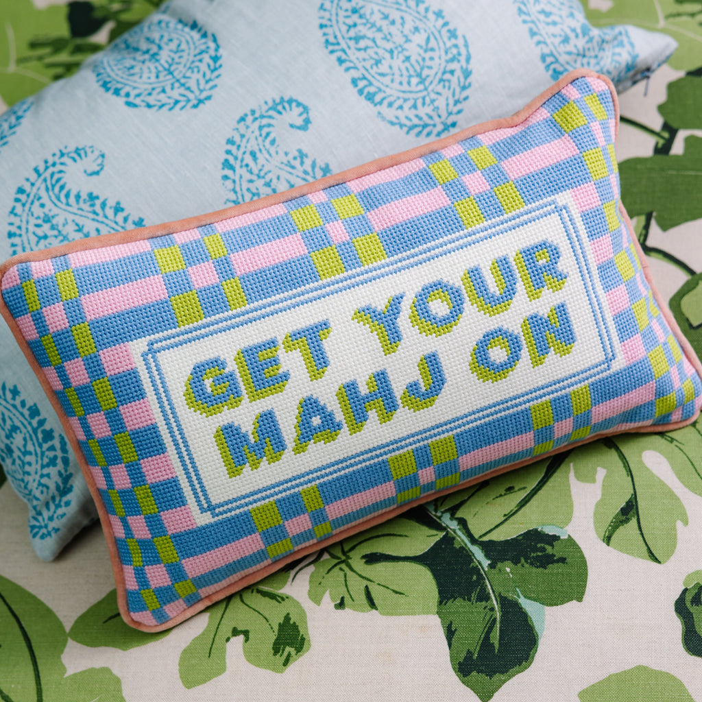 Decorative pillow with 'GET YOUR MAHJ ON' text on a patterned surface