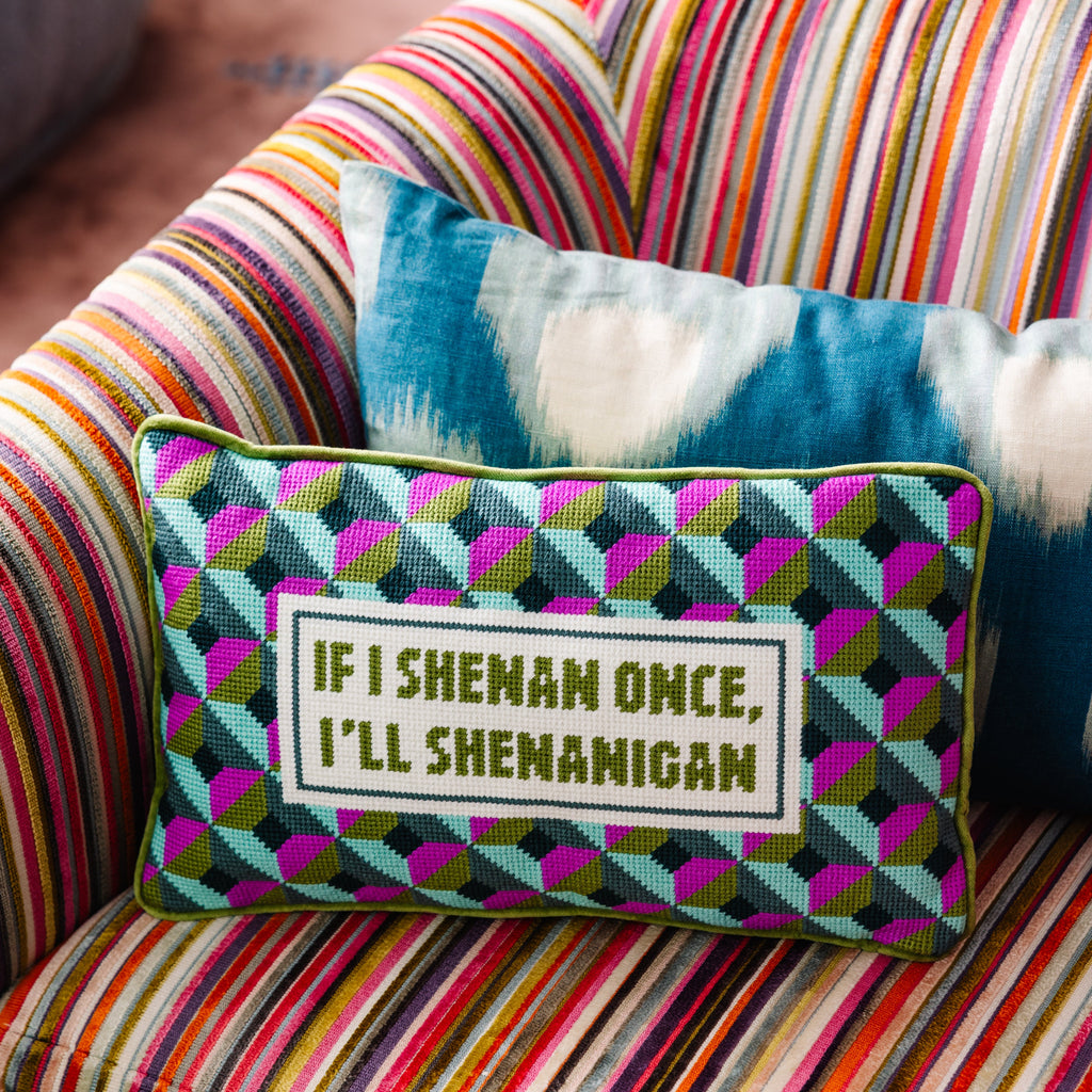 Decorative pillow with text on a colorful striped couch
