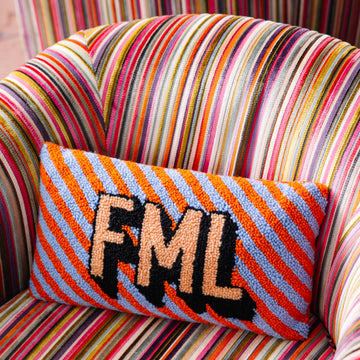Colorful striped chair with a knitted pillow displaying 'FML' on a multicolored background
