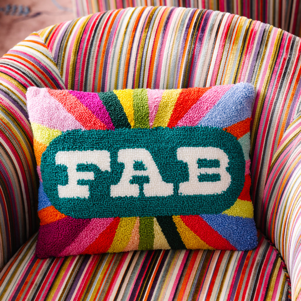 Colorful pillow with 'FAB' on a striped chair