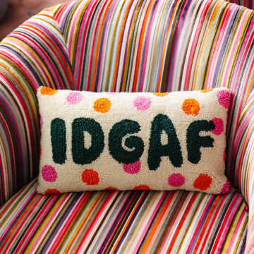 Decorative pillow with 'IDGAF' text on a colorful striped chair