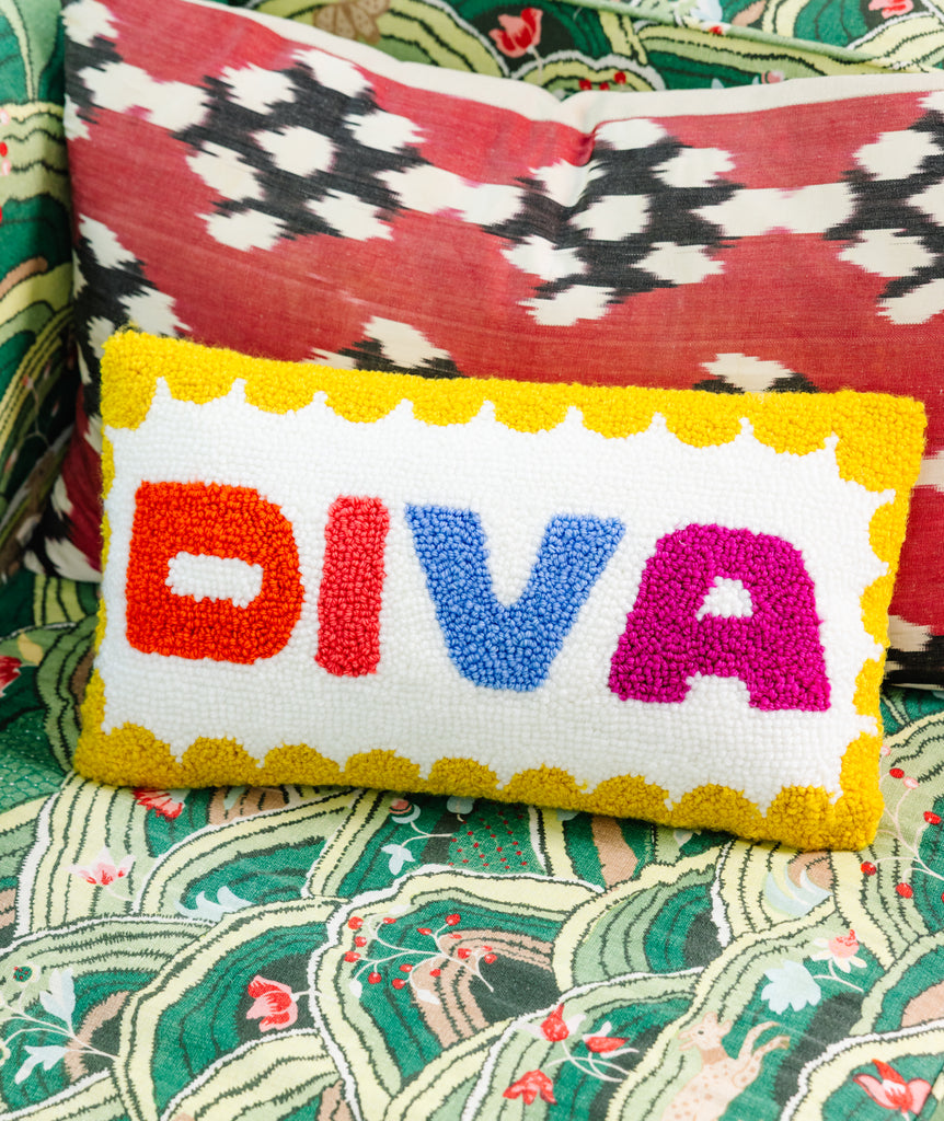 Decorative pillow with 'DIVA' text on a colorful patterned background