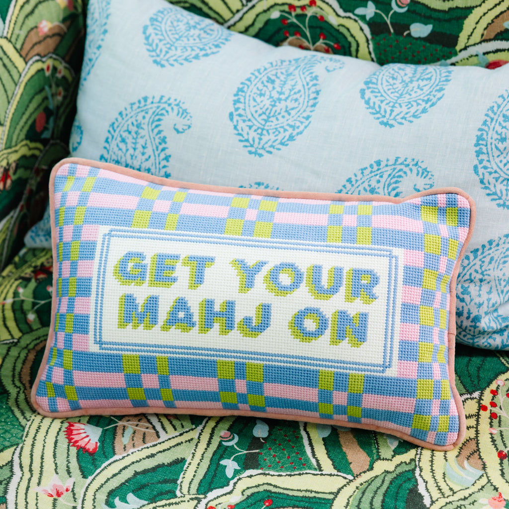 Decorative pillow with 'GET YOUR MAHJ ON' text on a patterned fabric background