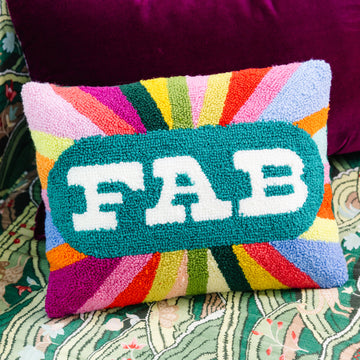 Colorful pillow with 'FAB' text on a patterned surface