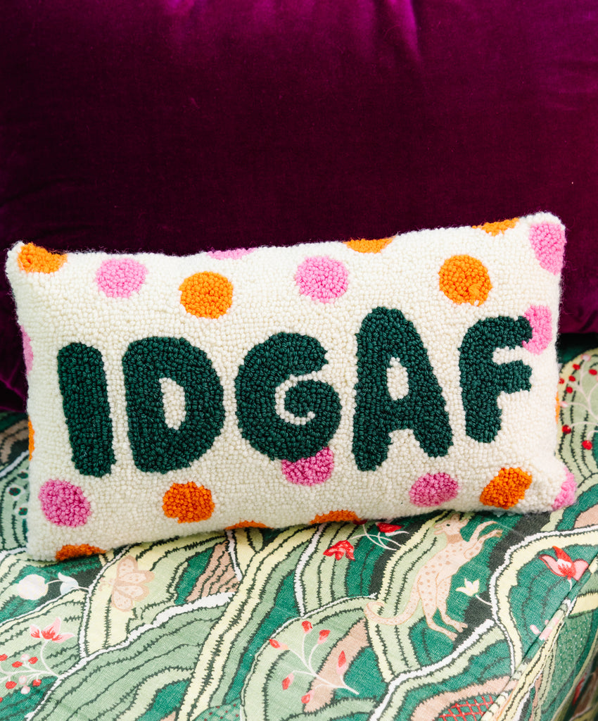 Decorative pillow with 'IDGAF' text on a patterned surface