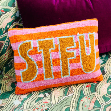 Decorative pillow with colorful text on a patterned couch