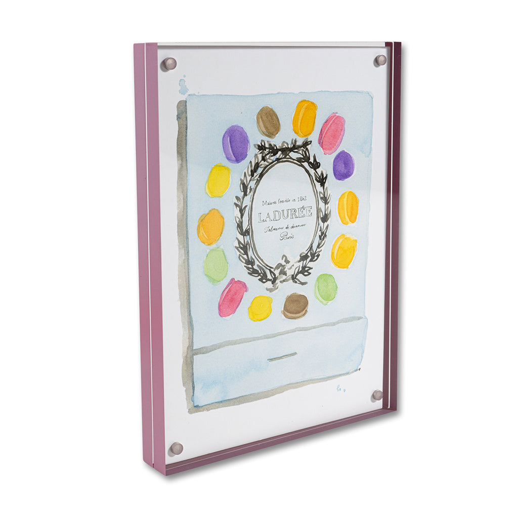 Ladurée Matchbook - Furbish Studio, Laduree matchbook watercolor print illustrating the Laduree's emblem surrounded by colorful macaroons with light blue background paint enclosed in a 5" x 7" mauve magnetic acrylic floating frame facing a side view