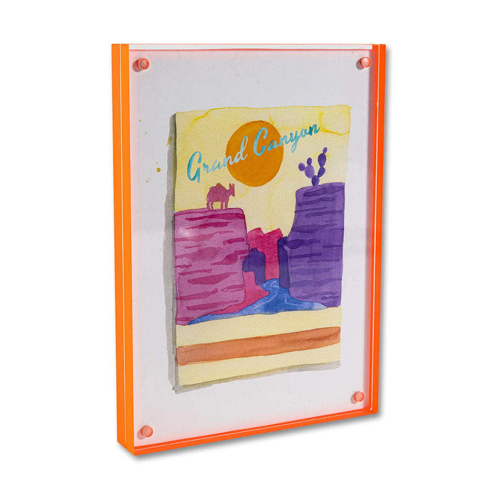 Grand Canyon Matchbook - Furbish Studio, A Grand Canyon matchbook watercolor print illustrating the trail in Grand Canyon National Park colored pink and purple with yellow-orange and a moon background enclosed in a 5" x 7" orange magnetic acrylic floating frame facing a side view