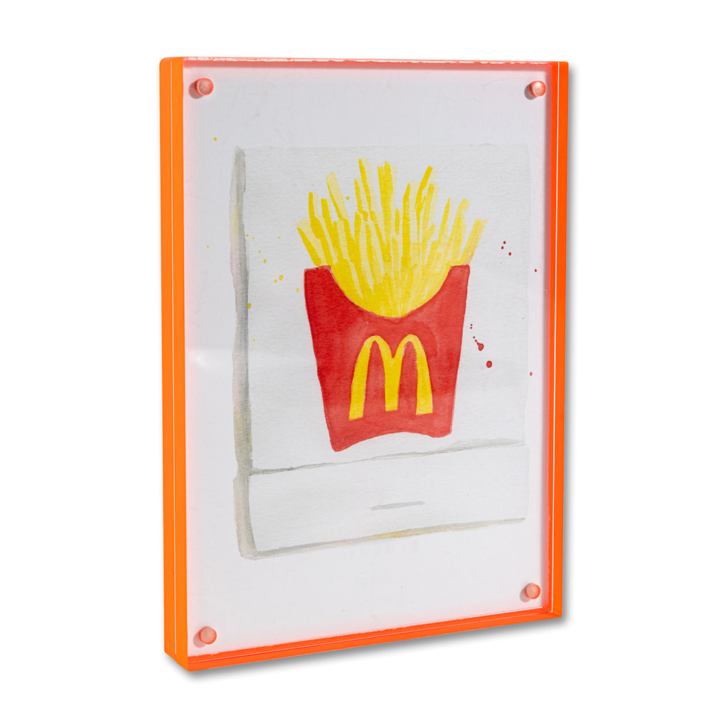McDonald's Matchbook - Furbish Studio, McDonald's matchbook watercolor print illustrating McDonald's signature french fries painted in the middle enclosed in a 5" x 7" orange magnetic acrylic floating frame facing a side view on top of a table