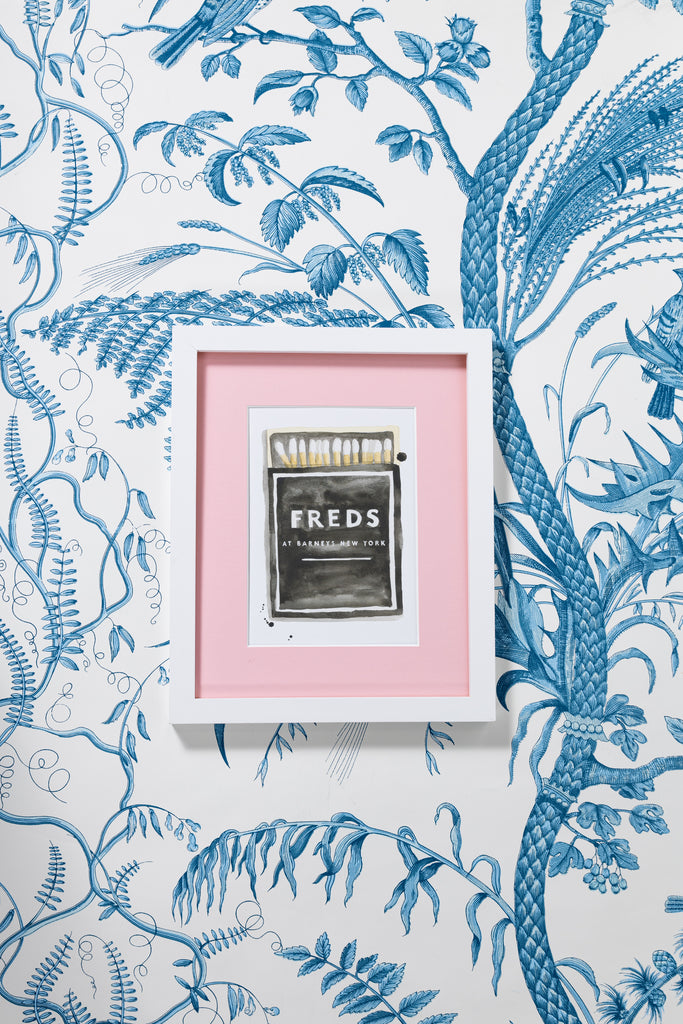 A Freds at Barneys NY Matchbook - Furbish Studio,  A Freds at Barneys NY matchbook watercolor print illustrating an opened matchbox painting with white heads and the title "Freds at Barneys New York" is painted in white in a white and pink frame attached to the wall