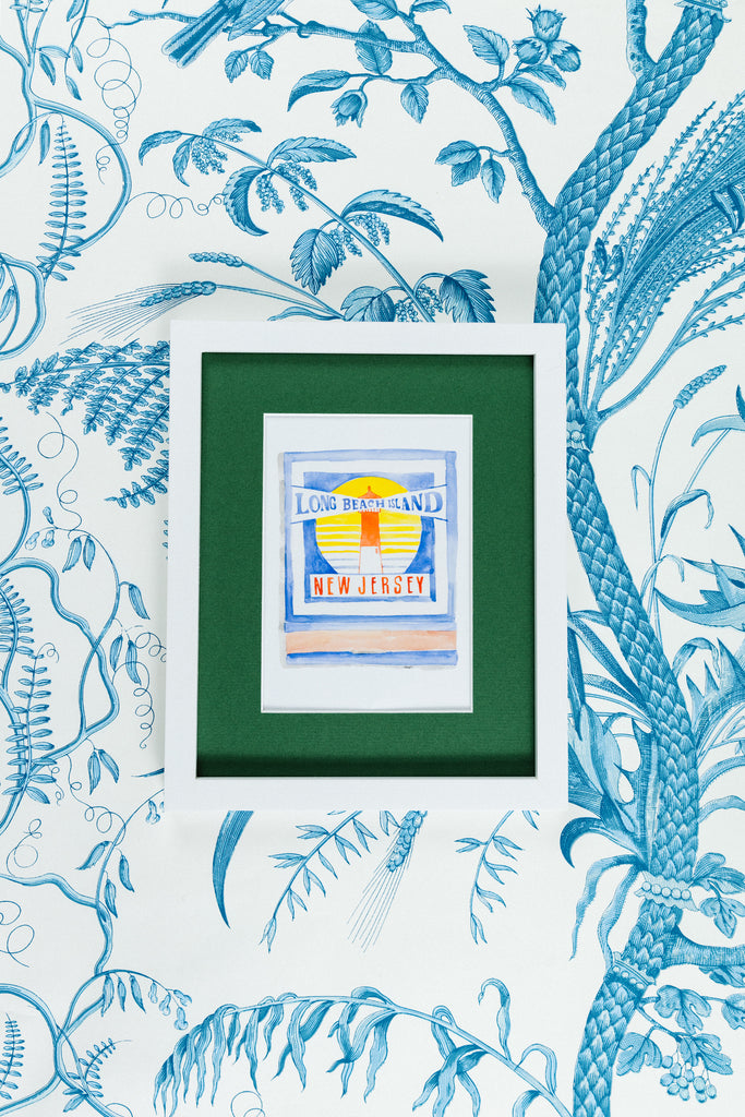 Long Beach Island Matchbook - Furbish Studio, Long Beach Island matchbook watercolor print illustrating the location's light house and the matchbook's title in the middle of it in a 5x7 white frame with a wallpaper background
