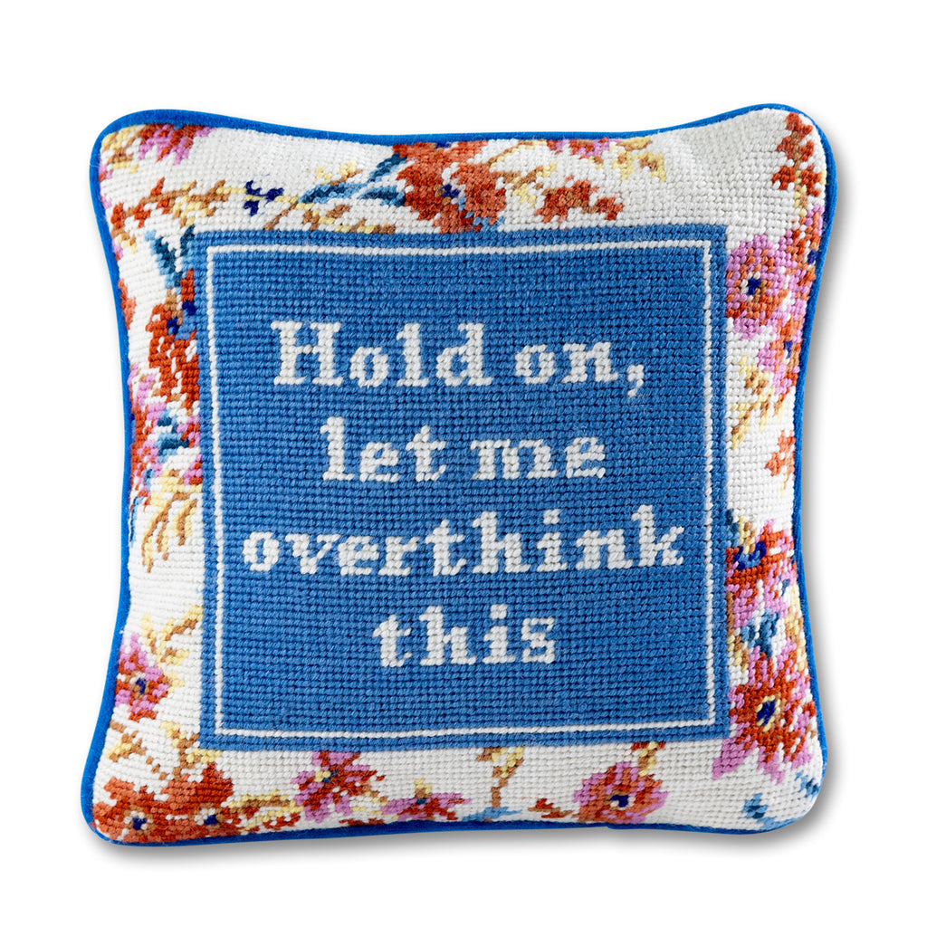 front view of the luxe blue grey velvet chic hand needlepoint pillow with "Hold on, let me overthink this" saying written in white enclosed in a square shaped blue grey design surrounded by colorful flowery patterns with a white backgound