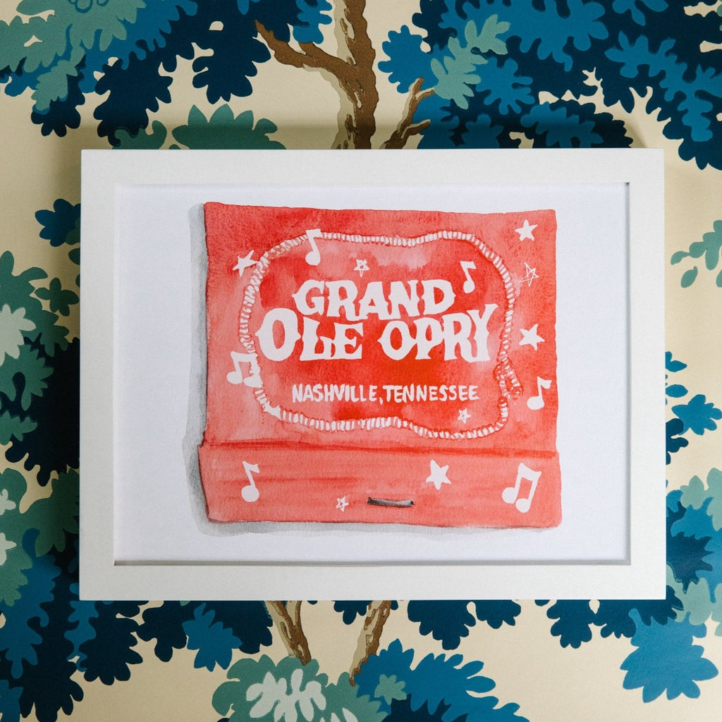 Grand Ole Opry Matchbook - Furbish Studio, A Grand Ole Opry matchbook watercolor print painted in orange with white notes and stars and The Title "Grand Ole Opry" in a white frame and is attached to the wall