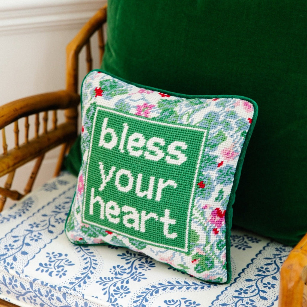 Bless Your Heart Needlepoint Pillow - Furbish Studio, side view of the luxe green velvet charming-meets-chic hand needlepoint pillow with "bless your heart" saying in front on a chair with a green pillow